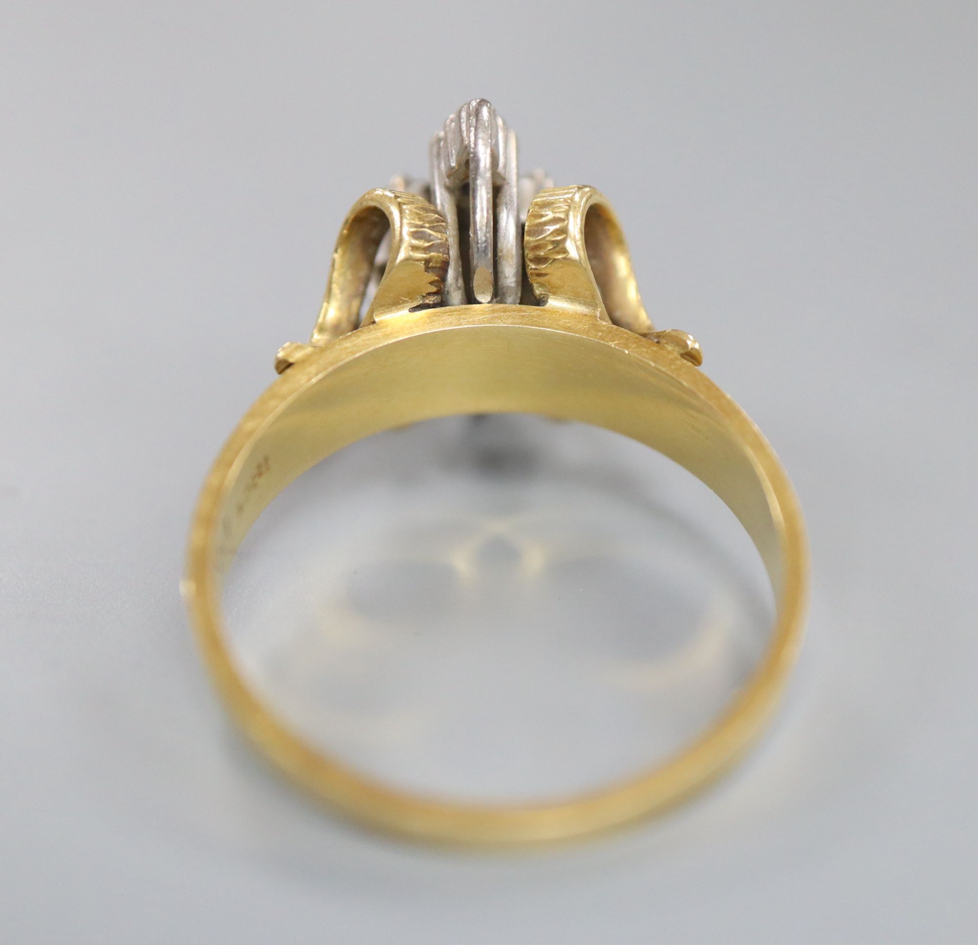 An 18ct and diamond cluster dress ring, in a raised setting, size Q/R, gross 5.9 grams.
